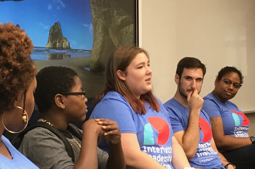 Keuka College Interfaith Youth Core members sitting in a row having a discussion